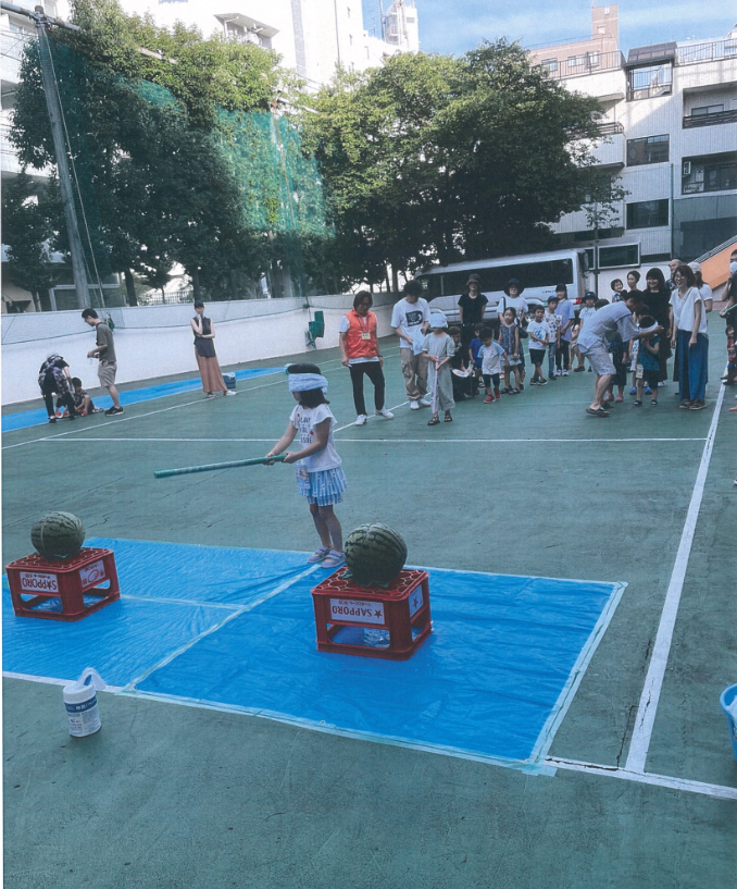 子どもたちがスイカ割りをしている写真