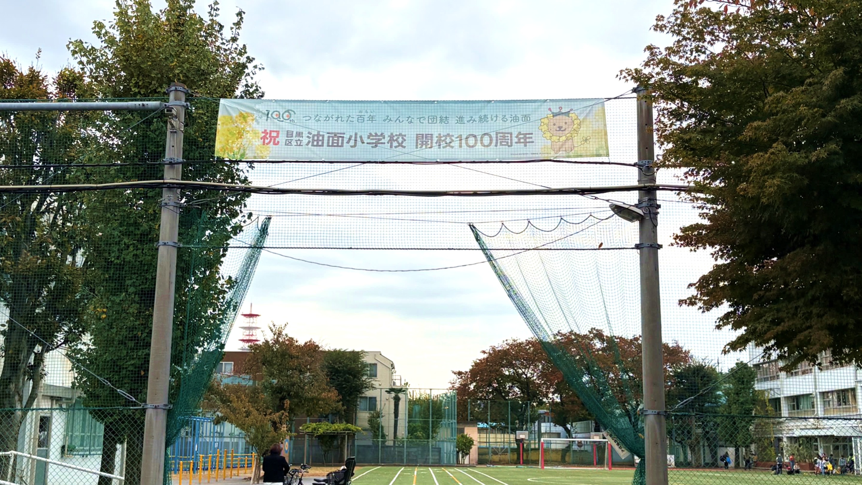 「祝 油面小学校 開校100周年」の横断幕がかけられた油面小学校の校庭。
