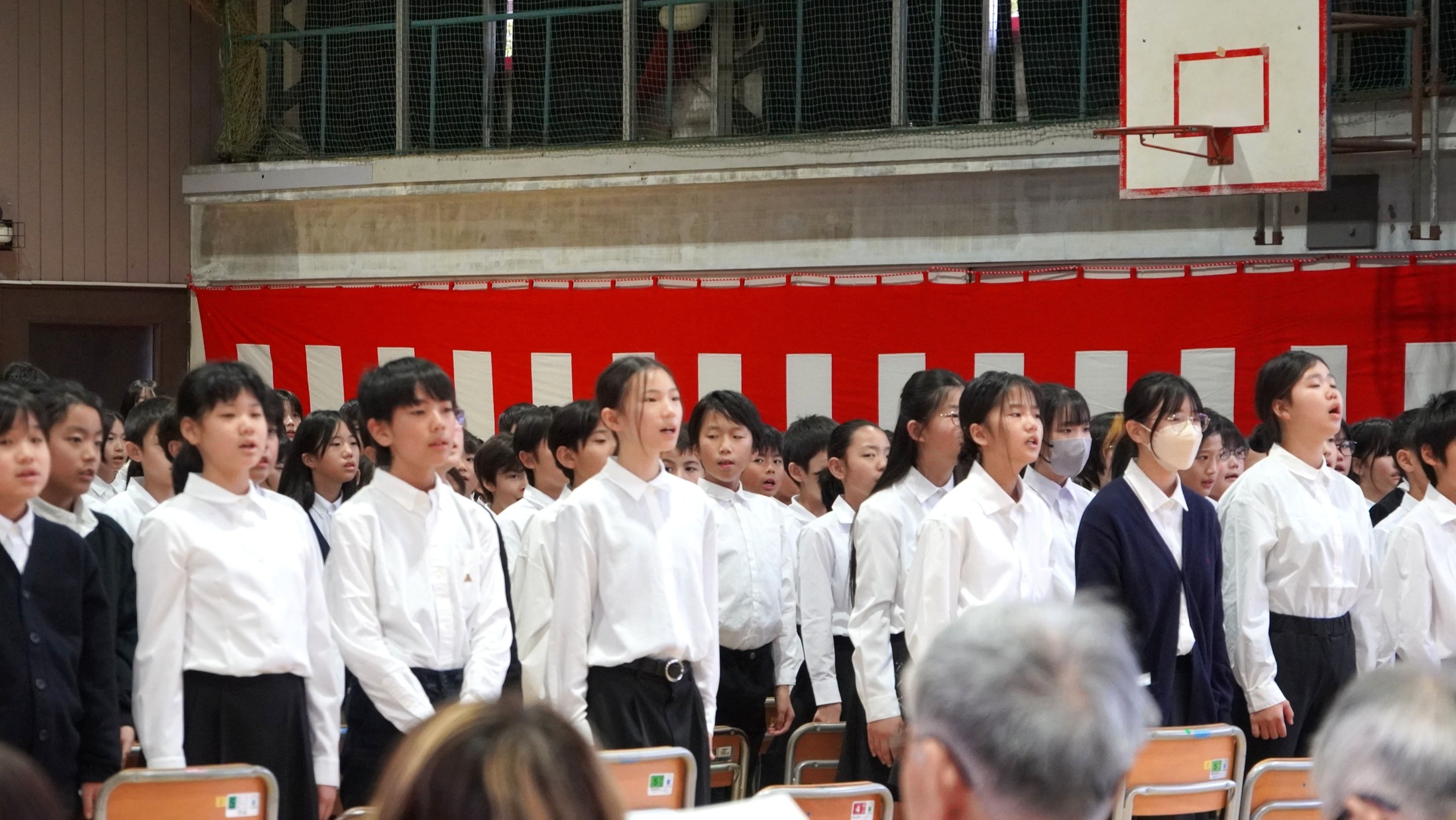 真剣なまなざしで「ずっとずっと 油面の空の下で」を歌う6年生の皆さん（別アングルからの写真）
