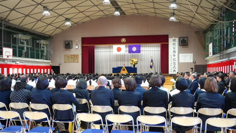 会場となる体育館。開式時刻が近づき、児童や教職員、保護者・来賓の方々が着席しています。