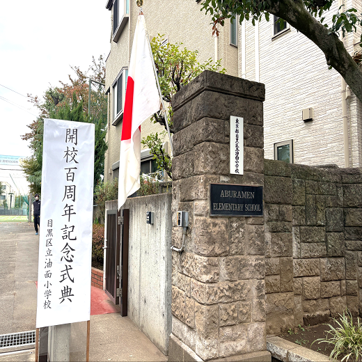 油面小学校開校100周年記念式典当日の校門。記念式典の看板と日本国旗が飾られている。
