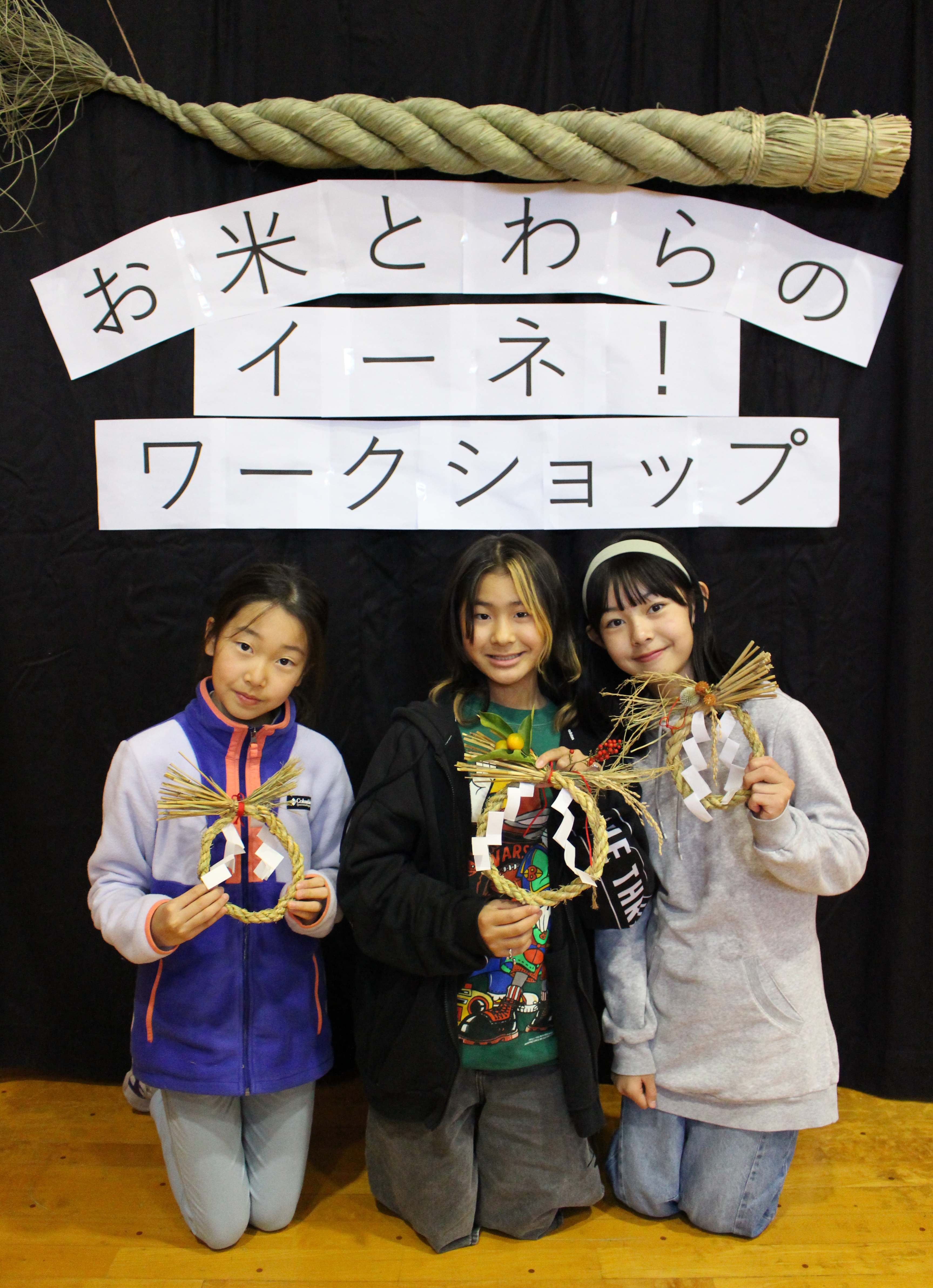 完成したしめかざりを持つ子どもたちの写真