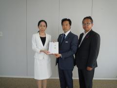 広島県東京事務所長に義援金を渡す写真