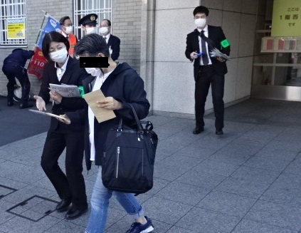 警察署員が、特殊詐欺被害に遭わないためのリーフレットを配布している写真