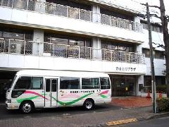 児童発達支援センターの建物とすくすくのびのび園の送迎バスの写真です。
