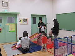 乳幼児のつどいで親子ですべり台で遊んでいる写真