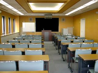 会議室の写真です。正面に演台があり、それを向くように机と椅子を配置できます